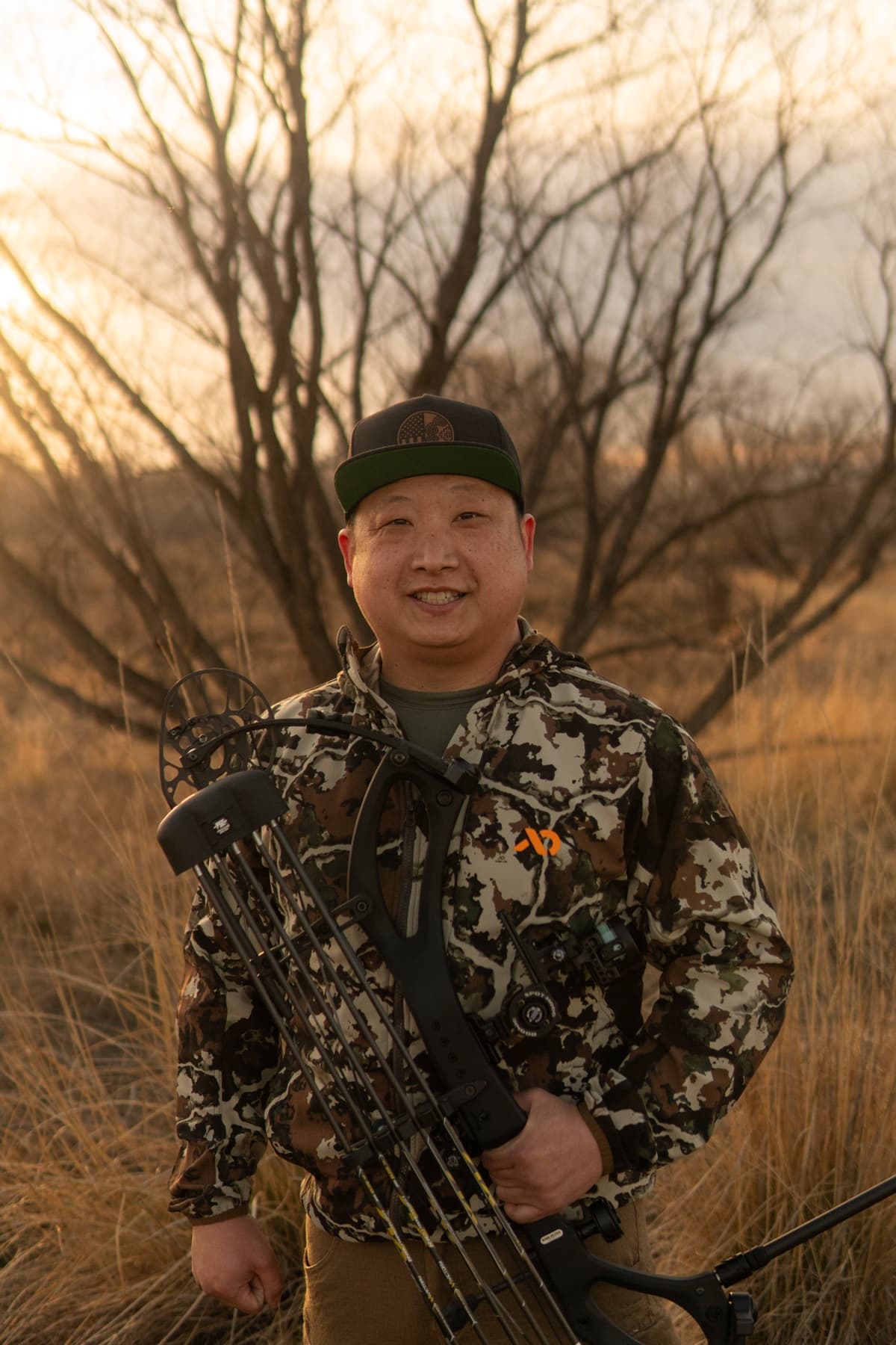 Albee, owner of SinnerShot Archery, in the field with his bow